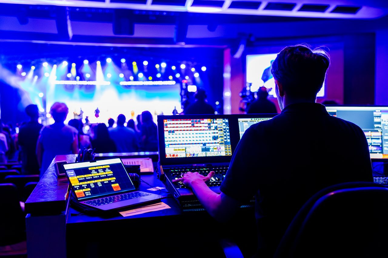 Crafting Captivating Headlines: Your awesome post title goes here Professional technician managing lighting and sound at a live concert, showcasing modern technical skills.