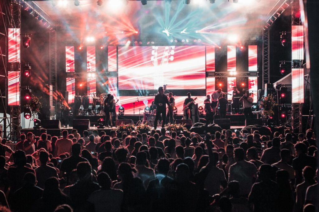 Vibrant outdoor concert event in Santa Marta with a lively crowd and colorful lighting effects.
